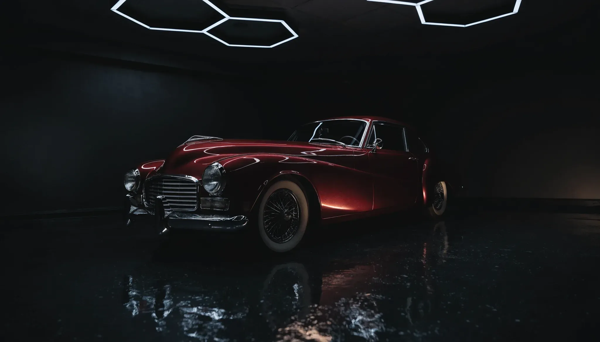 A restored classic grand tourer in deep oxblood, freshly detailed under studio lighting at JD Mobile Auto Detailing, Abbotsford