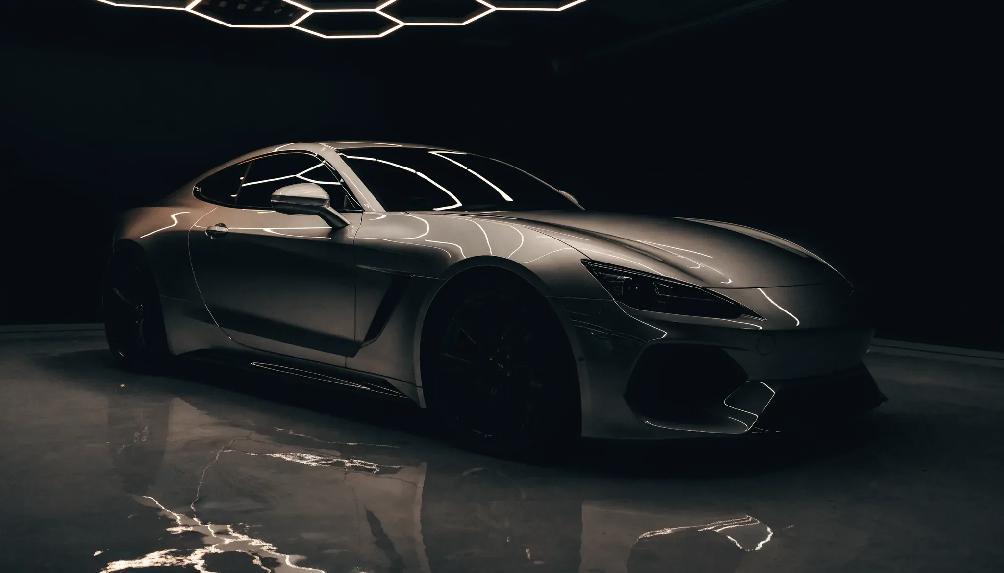 A gunmetal luxury sports coupe with a mirror-gloss finish under studio lighting at JD Mobile Auto Detailing, Abbotsford